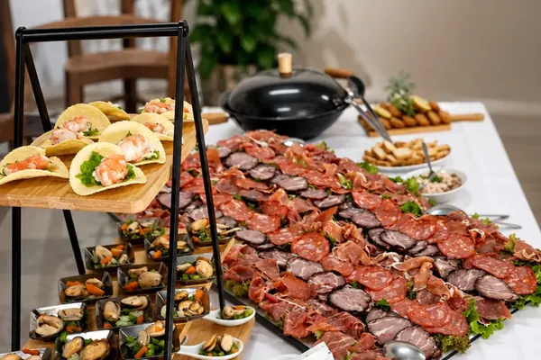 Mesa de um evento privado com petiscos, enchidos e salgados